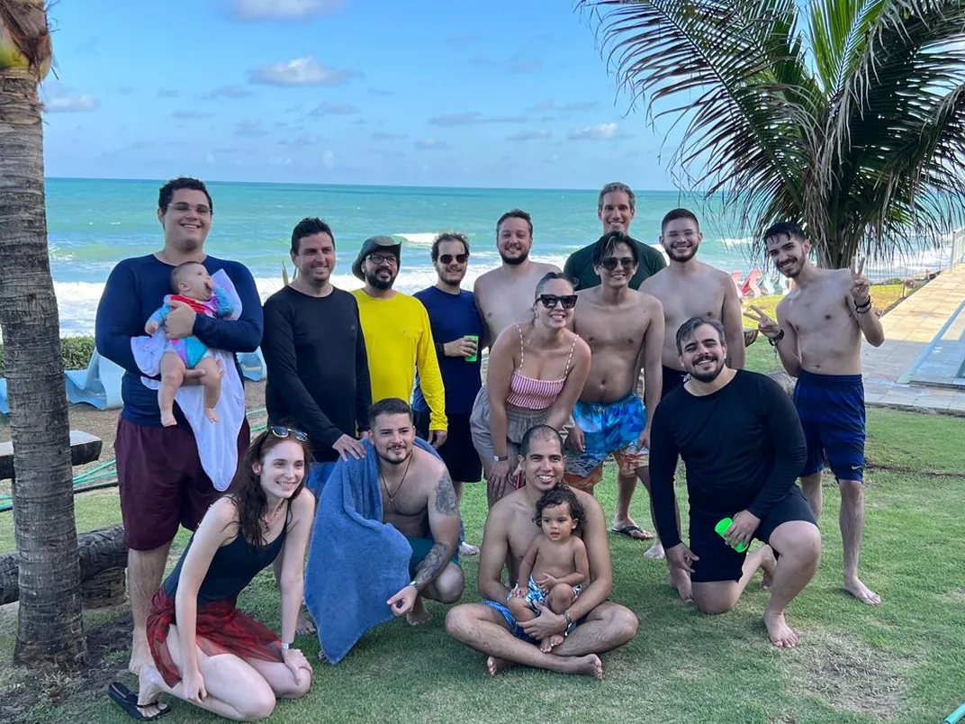 Equipe da Strategi e familiares em confraternização na praia