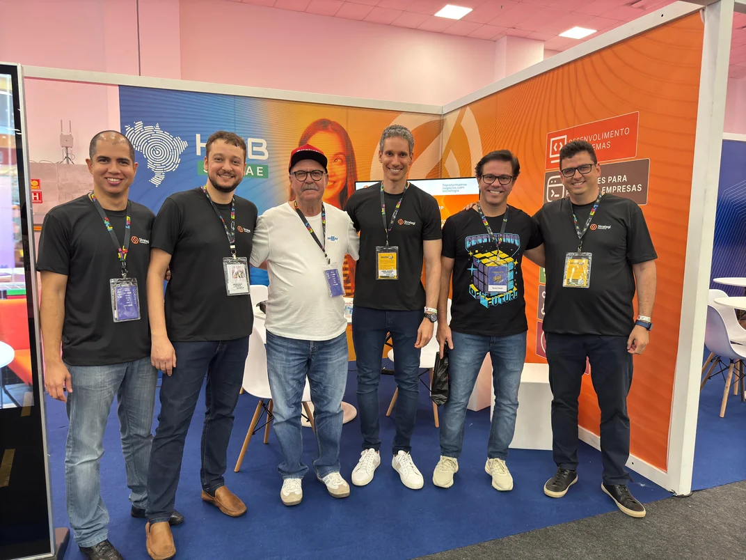 Time da Strategi recebendo visitantes no estande da feira go!RN